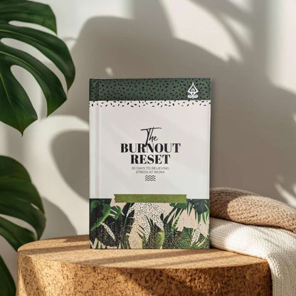 Guided journal titled 'The Burnout Reset' on a wooden surface with plants in the background