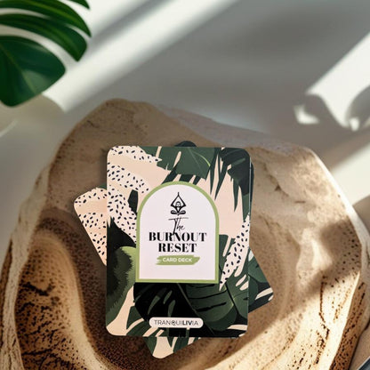 A mindful affirmation card deck titled 'The Burnout Reset' on a natural wood surface with a plant in the background.